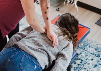 A female chiropractor adjusts a woman at Connected Chiropractic in Calgary, specializing in child and family chiropractic.